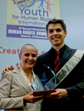 Dustin McGahee receives the Human Rights Hero Award from Dr. Mary Shuttleworth, President of Youth for Human Rights International, at the 8th Annual International Human Rights Summit in Geneva, Switzerland.